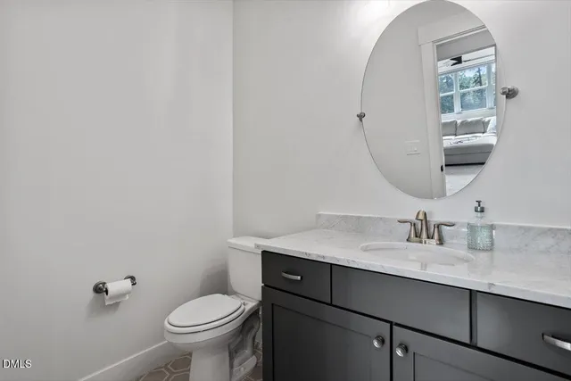 a bathroom with a granite countertop toilet sink and mirror