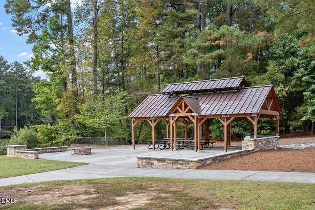 a view of a house with backyard and trees in the background