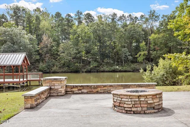 a view of a swimming pool with a patio and a yard