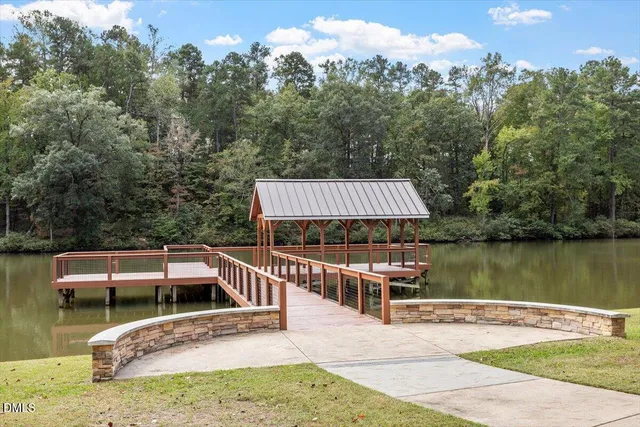 a view of a wooden deck and lake with trees in the background