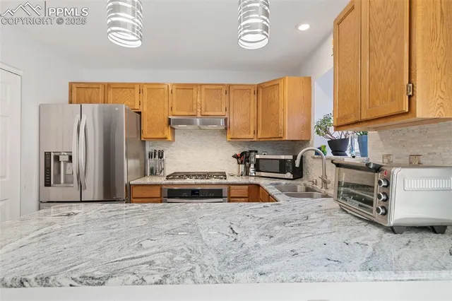 a kitchen with stainless steel appliances a refrigerator sink and cabinets