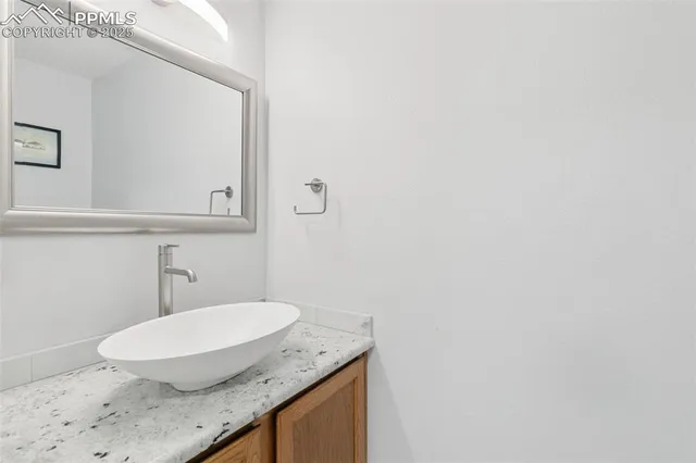 a bathroom with a granite countertop sink and a mirror