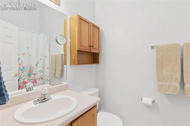 a bathroom with a sink vanity mirror and toilet