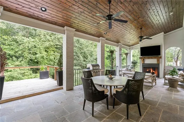 a living room with furniture a fireplace and a floor to ceiling window