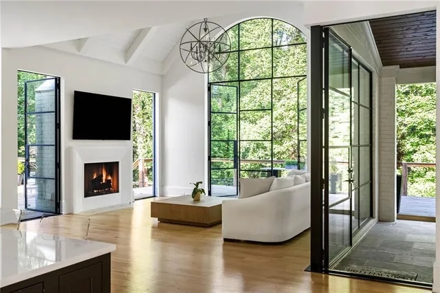 a kitchen with stainless steel appliances granite countertop a stove a refrigerator a sink a dining table and chairs with wooden floor