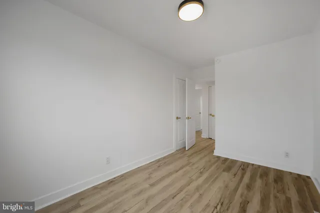a view of a room with wooden floor and white walls