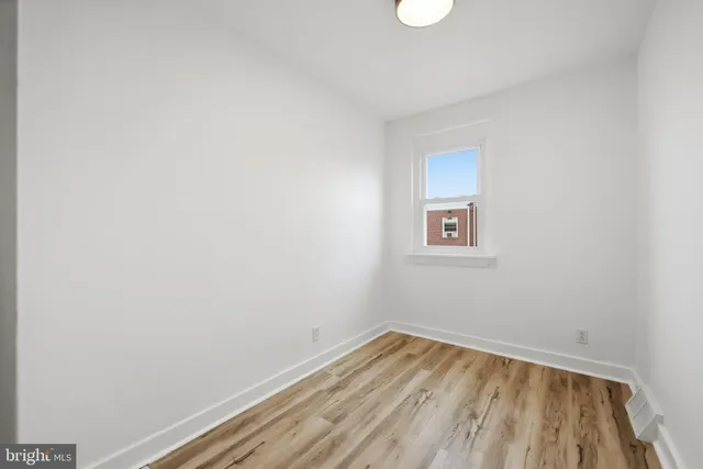 a view of a room with wooden floor and a window