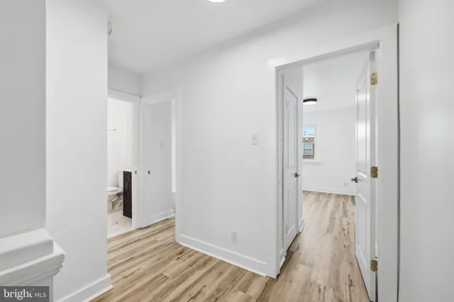 a view of a hallway with wooden floor and closet