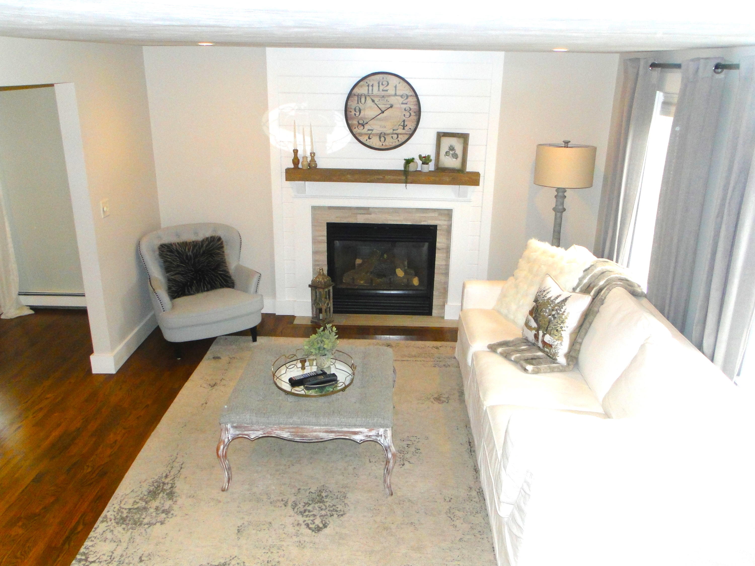 30 Brewster Road Mashpee, MA 02649 - Photo 22 of 58 a living room with furniture a clock and a fireplace
