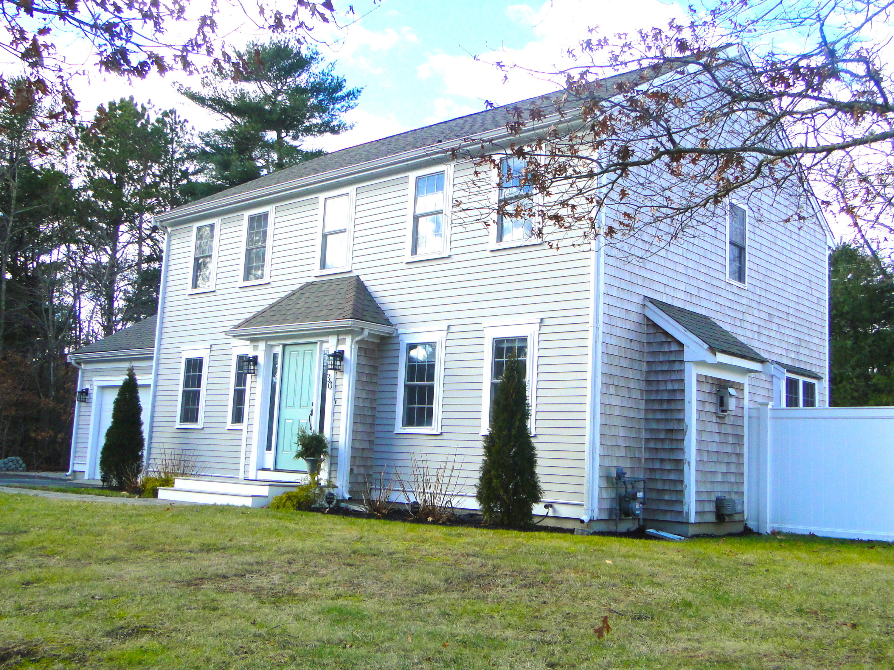 30 Brewster Road Mashpee, MA 02649 - Photo 53 of 58 a front view of a house with a yard and garage