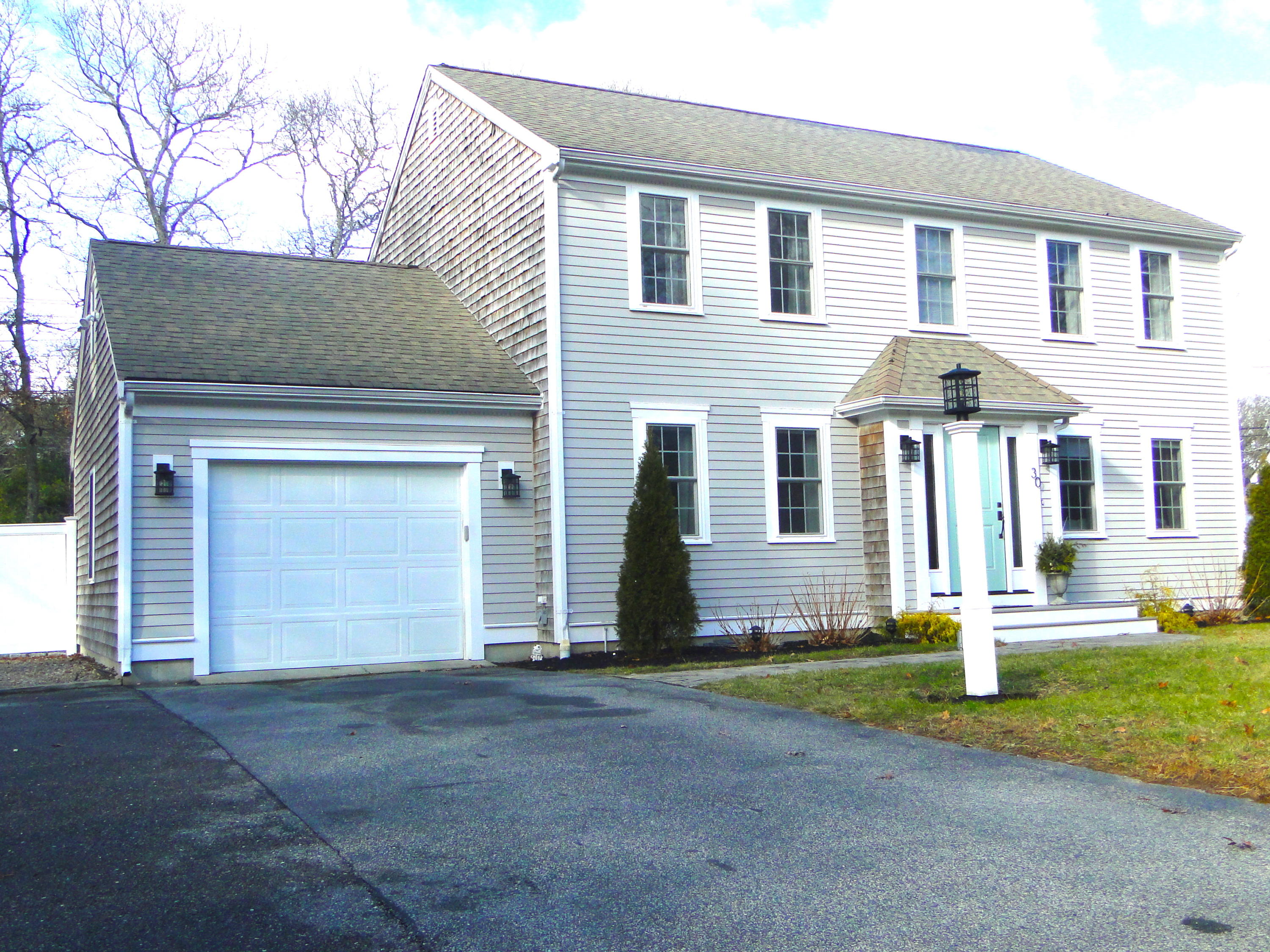 30 Brewster Road Mashpee, MA 02649 - Photo 58 of 58 a front view of a house with a yard and garage
