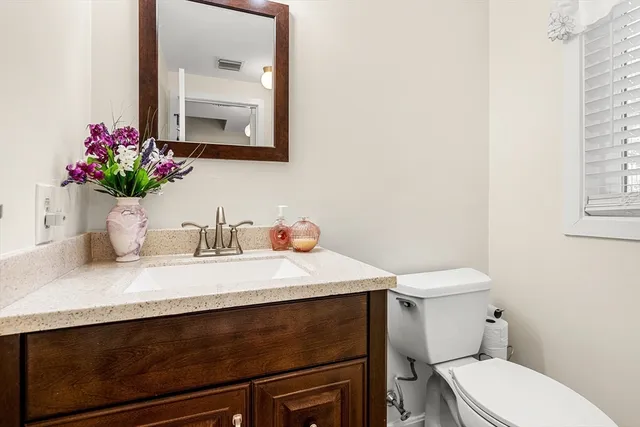 a bathroom with a sink a toilet and a mirror