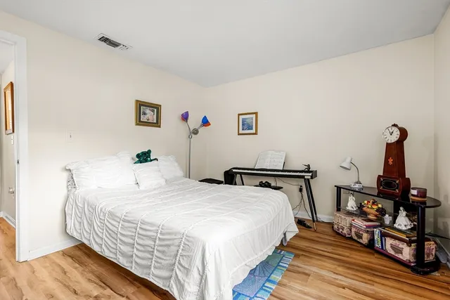 a bedroom with a bed and wooden floor