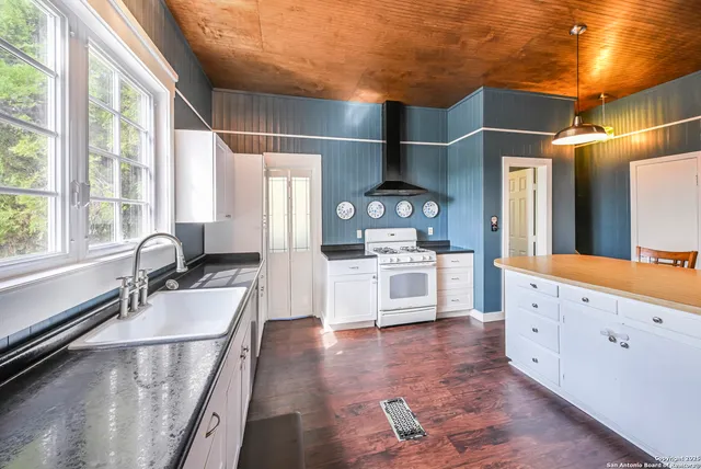 a large white kitchen with a large window