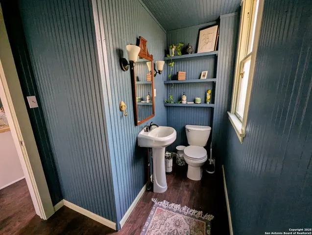 a bathroom with a sink a toilet and a mirror