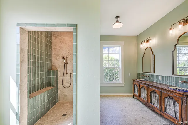 a bathroom with double vanity and a mirror