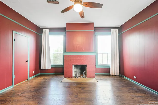 a view of empty room with wooden floor and fireplace