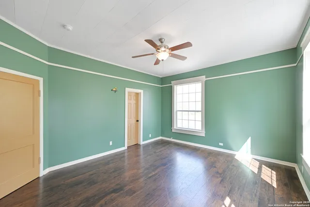 a view of a room with wooden floor and fan