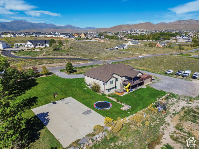 9044 North Cedar Pass Road Eagle Mountain, UT 84005 - Photo 52 of 63 Expansive property with a large concrete sport court, lush green lawn, and a multi-level deck