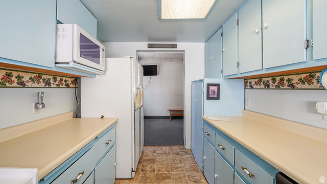 44 Shriver Street Eureka, UT 84628 - Photo 17 of 43 Galley-style kitchen featuring light blue cabinetry, light-colored countertops, and wood-finish flooring