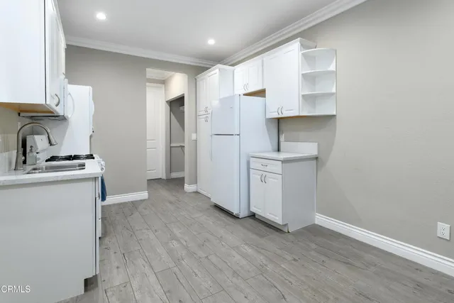 a kitchen with granite countertop white cabinets and white appliances