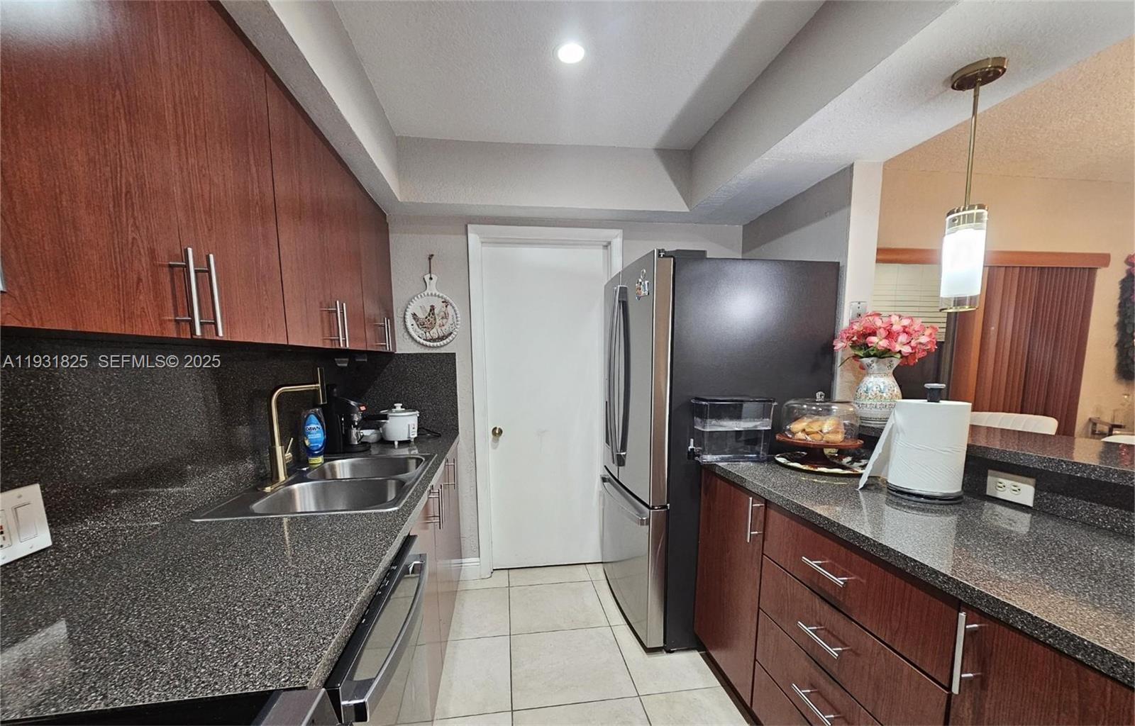 8401 Southwest 107th Avenue, Unit 117E Miami, FL 33173 - Photo 9 of 9 a kitchen with stainless steel appliances granite countertop a sink refrigerator and microwave
