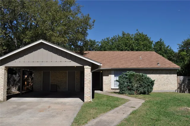 a front view of a house with a garden and yard