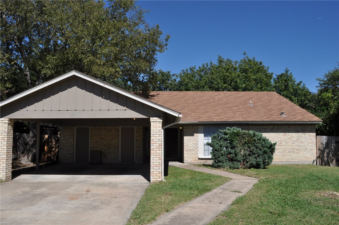 a front view of a house with a garden and yard