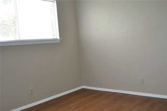 a view of a small space with wooden floor and a window