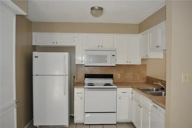 a kitchen with a refrigerator sink stove and cabinets