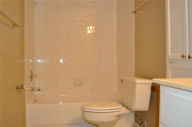 a white toilet sitting next to a bathroom sink and vanity