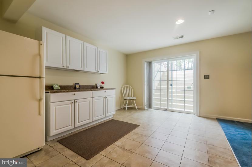 615 Sand Road Severn, MD 21144 - Photo 25 of 30 a kitchen with a refrigerator a stove top oven and white cabinets
