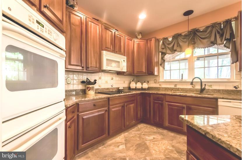 615 Sand Road Severn, MD 21144 - Photo 9 of 30 a kitchen with stainless steel appliances granite countertop a sink a stove and cabinets