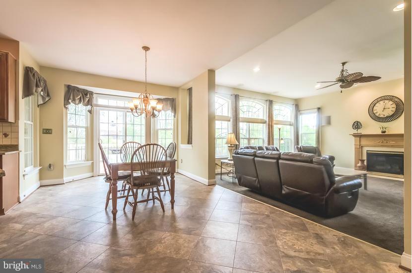 615 Sand Road Severn, MD 21144 - Photo 10 of 30 a dining room with furniture a fireplace and large windows