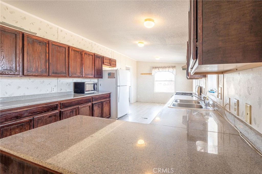 36249 Campbell Road Lucerne Valley, CA 92356 - Photo 12 of 32 a kitchen with stainless steel appliances granite countertop a sink stove and cabinets