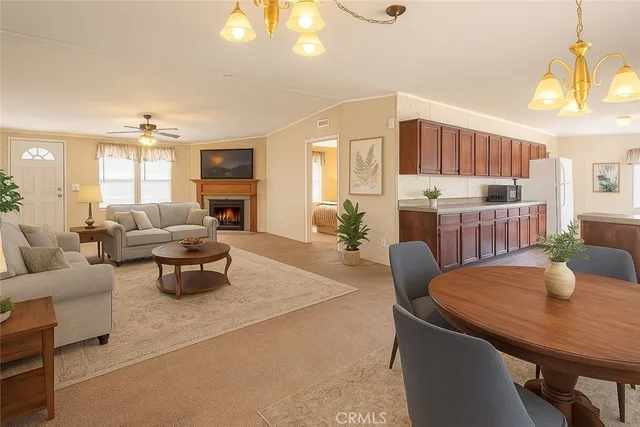 a living room with furniture a dining table and a chandelier