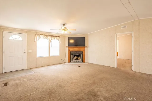 an empty room with windows and fireplace