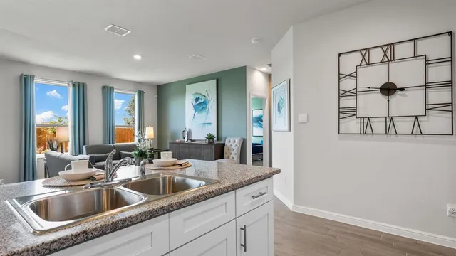 a kitchen with white cabinets and sink