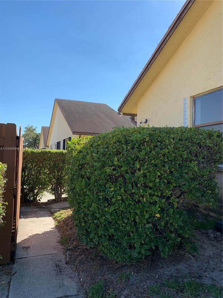464 Springdale Circle, Unit 46D Palm Springs, FL 33461 - Photo 15 of 21 a backyard of a house with plants and tree