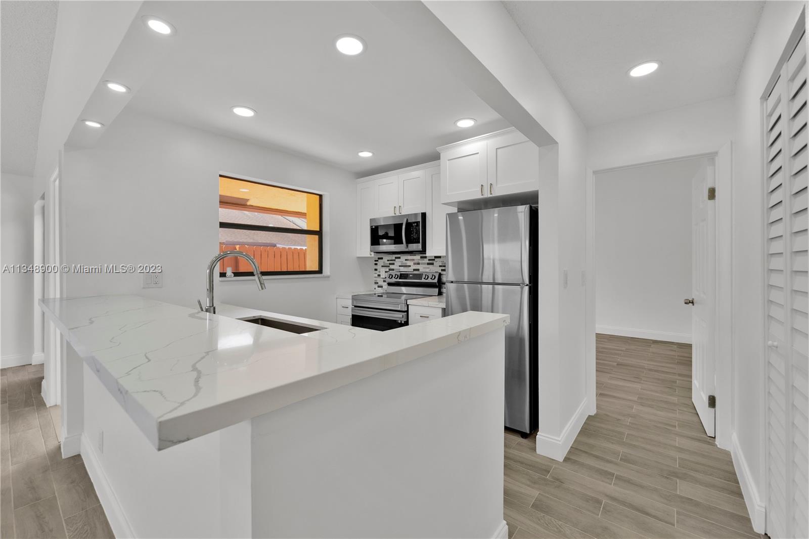 464 Springdale Circle, Unit 46D Palm Springs, FL 33461 - Photo 5 of 21 a kitchen with stainless steel appliances a refrigerator sink and microwave