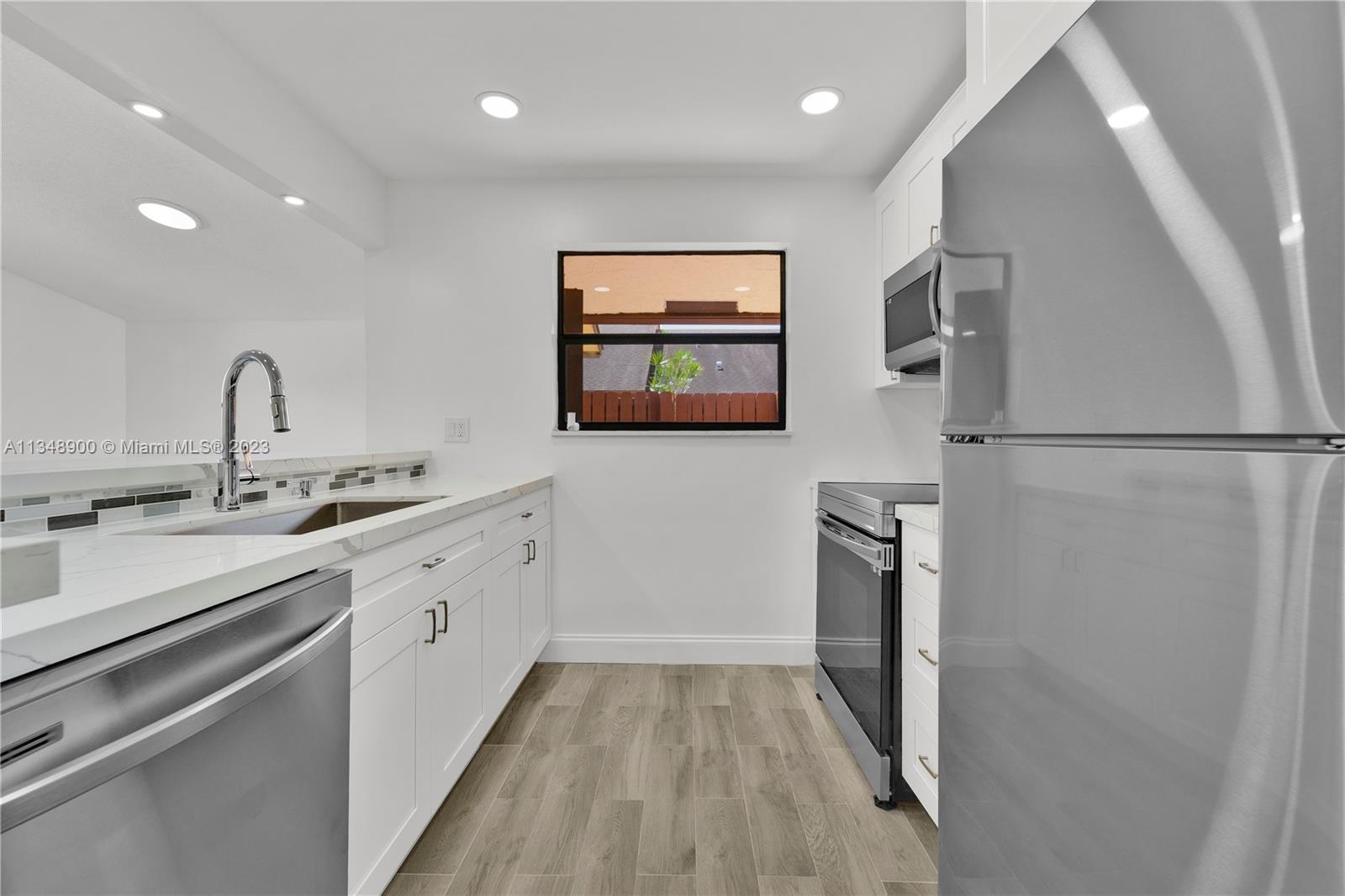 464 Springdale Circle, Unit 46D Palm Springs, FL 33461 - Photo 6 of 21 a kitchen with a refrigerator and a sink