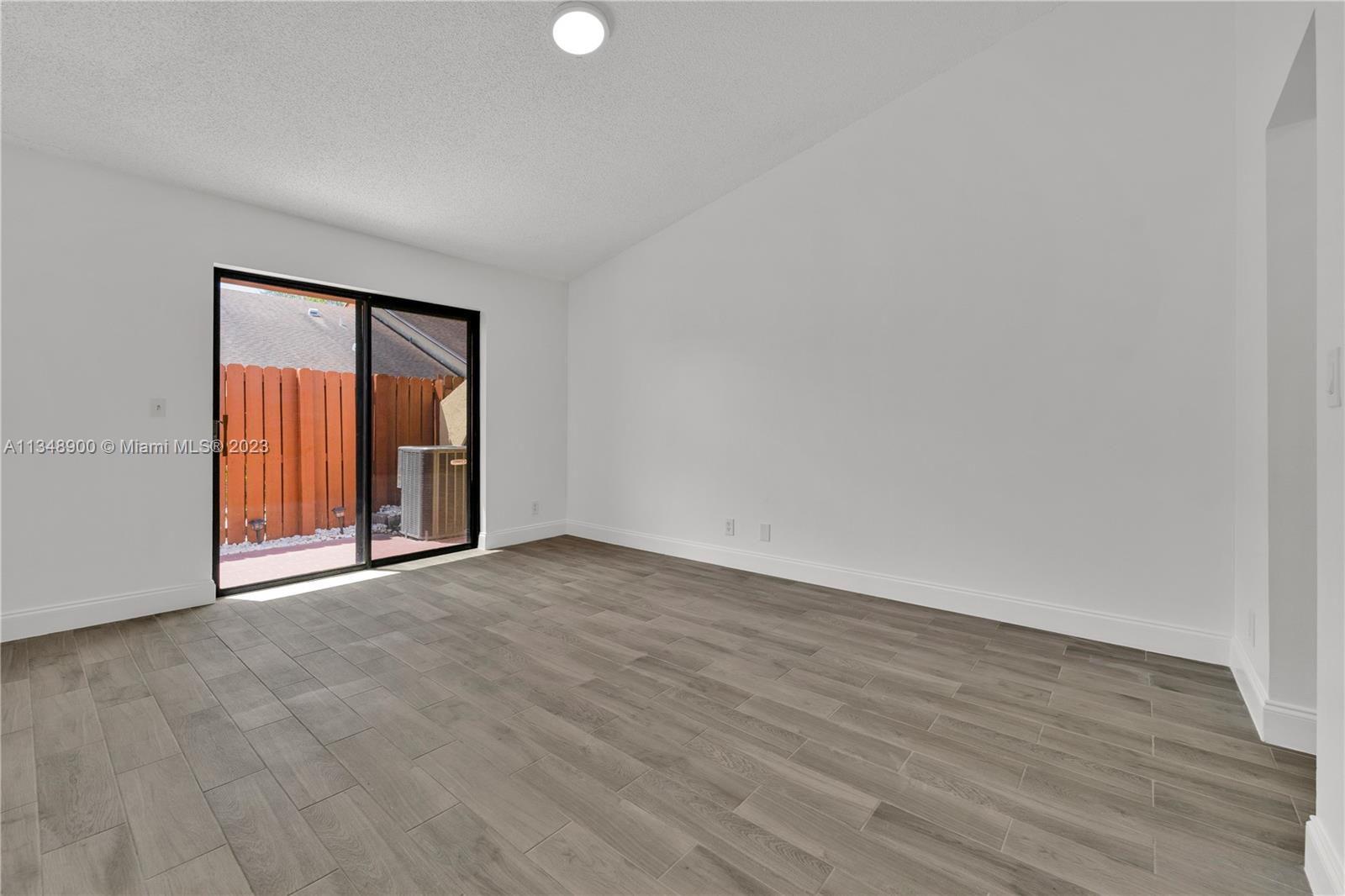 464 Springdale Circle, Unit 46D Palm Springs, FL 33461 - Photo 7 of 21 a view of an empty room with wooden floor and a window