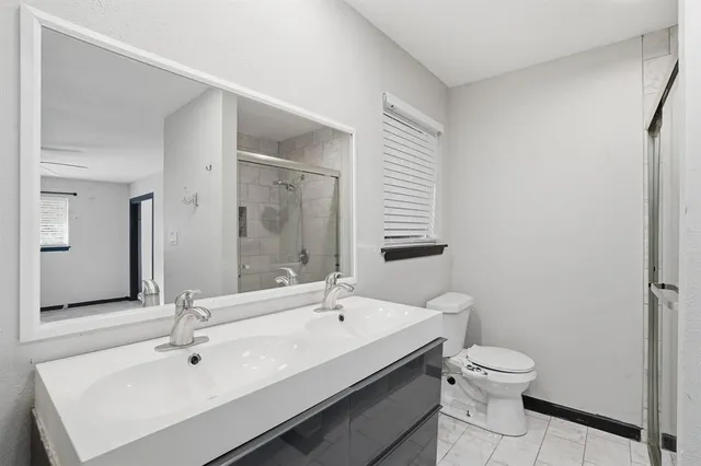 a bathroom with a sink mirror and toilet