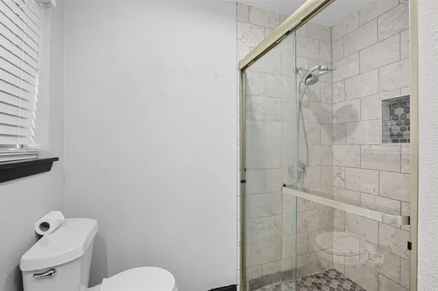 a bathroom with a toilet and a shower