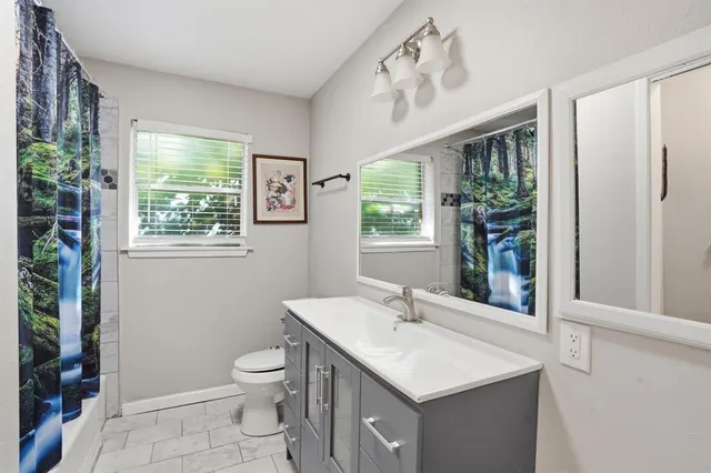 a bathroom with a toilet a sink and a large mirror