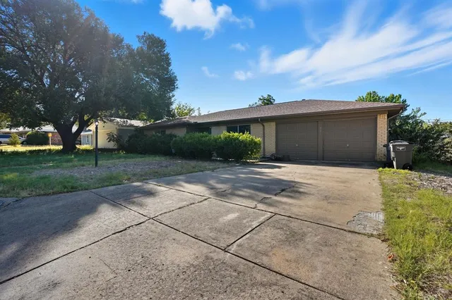 a front view of a house with a yard and potted plants