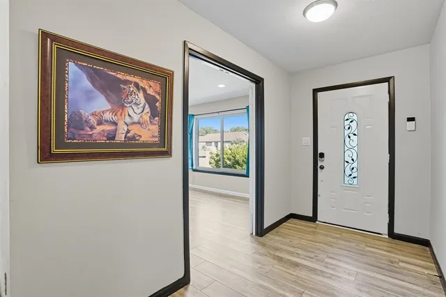 a view of a hallway with wooden floor and closet