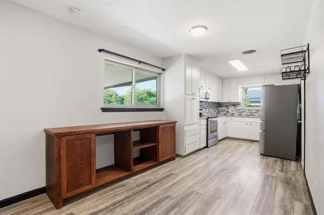 a kitchen with a sink cabinets stainless steel appliances and windows