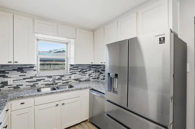 a kitchen with stainless steel appliances granite countertop a refrigerator and a sink