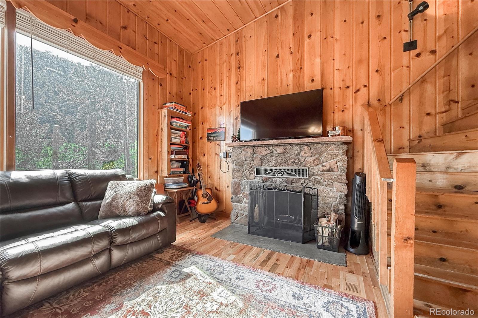 3148 Riverside Drive Lyons, CO 80540 - Photo 15 of 41 a living room with furniture a flat screen tv and a fireplace